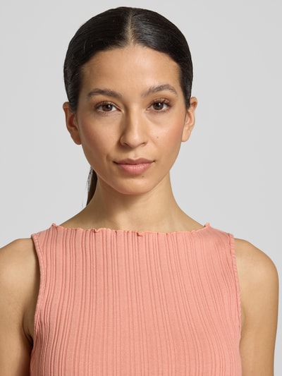 Frauenmodel trägt Stricktop mit Strukturmuster und Rundhalsausschnitt von Scotch & Soda aus Baumwoll-Elasthan-Mix, Nahaufnahme Oberkörper.