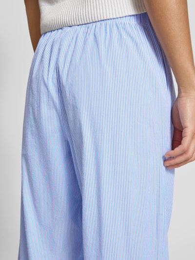 Männermodel trägt Loose Fit Weite Hose aus reiner Baumwolle Modell 'AUGUSTA' von Only, jasnoniebieskie paski, elastyczny pas z troczkiem, tkanina gładka, wzór allover, kieszeń z boku, kontekst: damska szeroka spodnia, widok z tyłu detailaufnahme