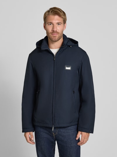 Männermodel trägt Regular Fit Jacke mit Stehkragen von Emporio Armani in Dunkelblau, Zweiwege-Reißverschluss, Ganzkörperansicht von vorne.
