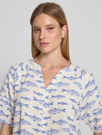 Vrouwenmodel draagt Blusenshirt im Allover-Look Modell 'SADIRA' van Stefanel, puur katoen, regular fit, V-hals, all-over look met blauwe vissen op lichte achtergrond, ruglengte maat S 53 cm, mouwlengte maat S 25 cm, Nahaufnahme Oberkörper.