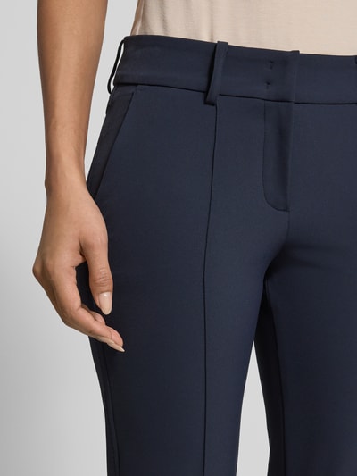 Kobiece model prezentuje spodnie materiałowe Flared Stoffhose in verkürzter Passform Modell 'FARAH' od Cambio, mieszanka materiałów z dodatkiem streczu, rozkloszowany krój, wpuszczane kieszenie, kolor granatowy, skrócony krój, detailaufnahme.