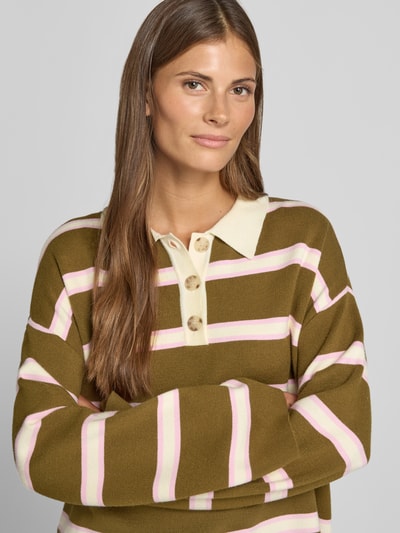 Frauenmodel trägt Pullover aus Viskose-Mix mit Polokragen Modell 'ISABELL' von YAS, gestreift in Braun, Rosa und Creme, Nahaufnahme Oberkörper.