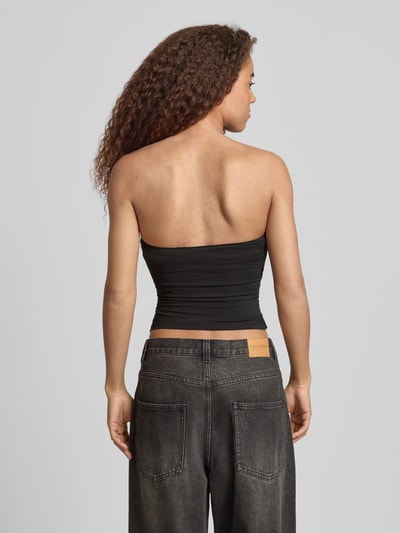 Frauenmodel trägt schmal geschnittenes Bandeau-Top von REVIEW aus schwarzem Baumwoll-Elasthan-Mix, Slim-Fit, Off-Shoulder-Look, Elastisch, Rückenlänge bei Größe S 28 cm, Rückenansicht, Ganzkörperansicht Rückansicht.