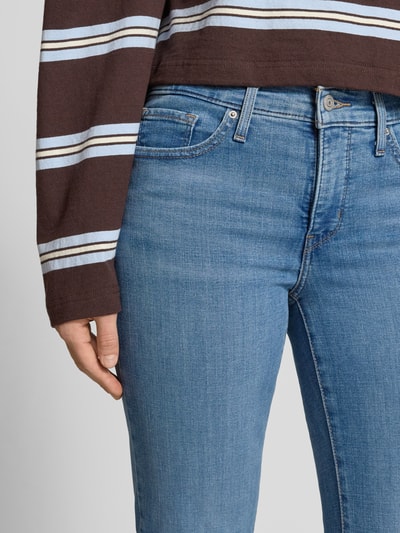 Kobieta nosi Straight Fit Jeans mit Label-Patch Modell '314™ SHAPING STRAIGHT' od Levi's®, jasnoniebieski denim, pięć kieszeni, zbliżenie na biodra i talię.