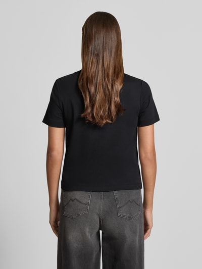 Frauenmodel trägt Boxy Fit T-Shirt aus reiner Baumwolle von s.Oliver RED LABEL in Schwarz, unifarben, kurzarm, Rundhals, Ganzkörperansicht Rückansicht.