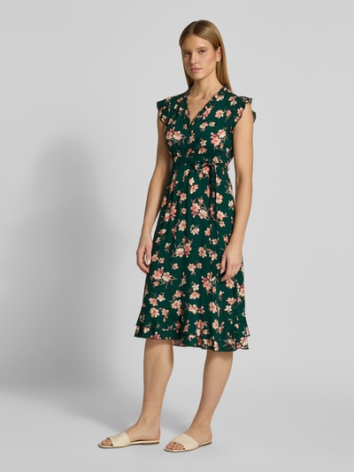 Frauenmodel trägt Kleid aus Viskose mit Bindegürtel und Volantsaum von Apricot, florales Muster, Grüntöne, Taillierter Schnitt, Midikleid, V-Ausschnitt, kurze Knopfleiste, Reine Viskose, Rückenlänge 94 cm, Brustweite 51 cm, Ärmellänge 7 cm, Ganzkörperansicht von vorne.