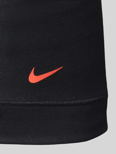 Männermodel trägt Micro Trunks im 3er-Pack mit Logo-Bund von Nike, schwarzer Material-Mix mit Stretch-Anteil, Logo-Print, Nahaufnahme Oberschenkel.