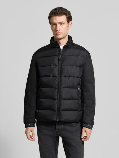 Männermodel trägt schwarze Regular Fit Steppjacke mit Stehkragen Modell 'Ciscos' von JOOP! COLLECTION, Ganzkörperansicht von vorne.