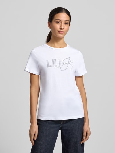 Frauenmodel trägt T-Shirt mit Label-Detail von Liu Jo White, Slim Fit, reine Baumwolle, Weiß, gerippter Rundhalsausschnitt, Ganzkörperansicht von vorne.