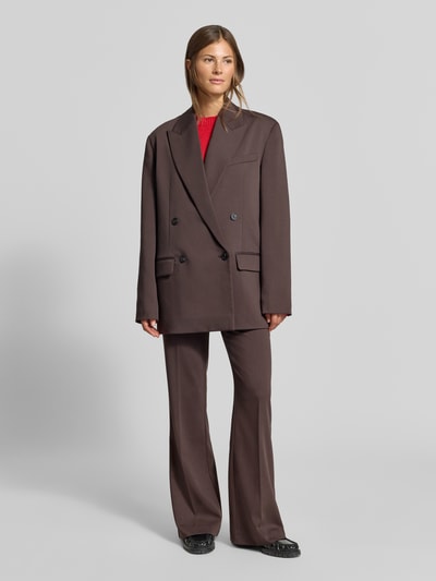 Frauenmodel trägt Oversized Blazer mit Viskose-Anteil von MYON in Braun, doppelte Knopfleiste, Reverskragen, Ganzkörperansicht von vorne.