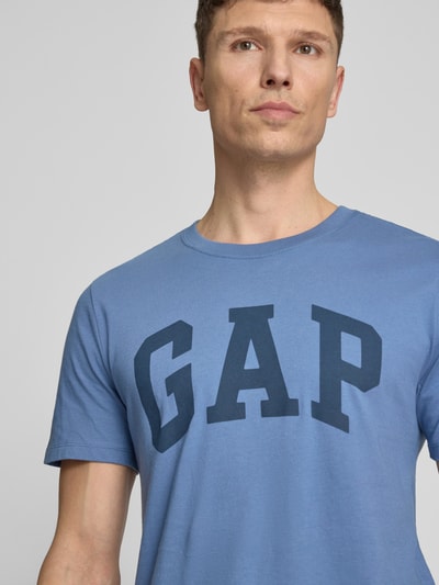 Männermodel trägt T-Shirt mit Logo und Rundhalsausschnitt von GAP, Reine Baumwolle, Regular-Fit, Logo, Rückenlänge 72 cm, Nahaufnahme Oberkörper.