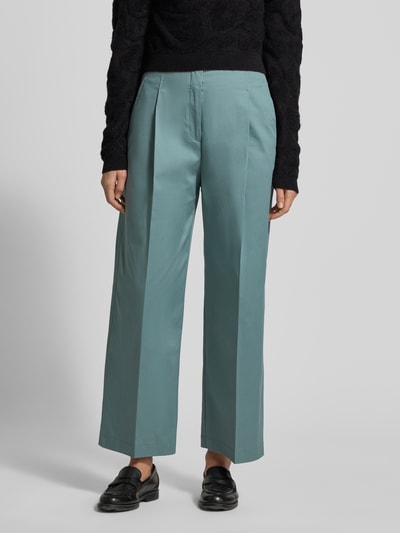 Frauenmodel trägt Straight Leg Bundfaltenhose aus Baumwoll-Mix Modell 'TULOTTA' von BOSS in Blaugrün mit Bügelfalten und seitlichen Taschen, Nahaufnahme Oberkörper.