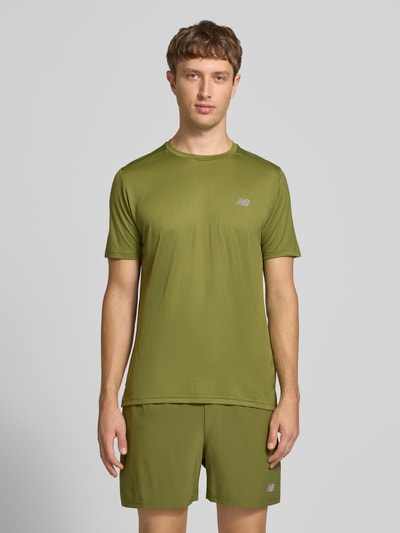 Männermodel trägt T-Shirt mit Label-Print Modell 'ESSENTIAL' von New Balance in Olivgrün, glatte Oberfläche, Ganzkörperansicht von vorne. Herren T-Shirt, gerader Schnitt, Rundhalsausschnitt, Rückenlänge Größe M 71 cm.