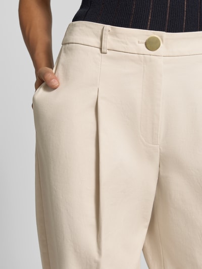 Vrouwenmodel draagt Hose mit Bundfalten van Armani Exchange in beige, mix van katoen en elastaan, regular fit, knoop- en ritssluiting, bandplooien, bandwijdte maat 36: 39 cm, binnenbeenlengte maat 36: 80 cm, detailopname.