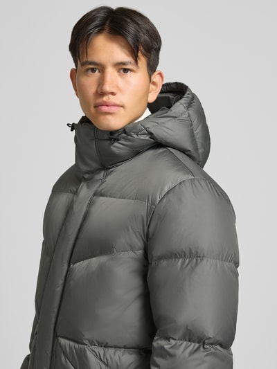 Männermodel trägt Regular Fit Steppmantel mit Kapuze von Marc O'Polo DENIM in Grau, glatte Oberfläche, Nahaufnahme Oberkörper.