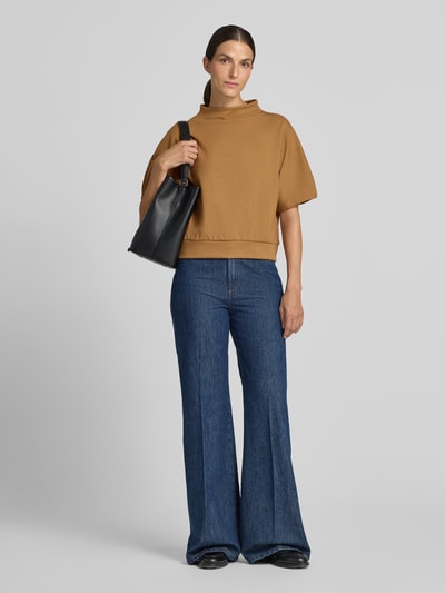 Frauenmodel trägt Regular Fit Sweatshirt mit Baumwoll-Modal-Anteil Modell 'Golli' von OPUS in Camel mit blauen Schlagjeans, Ganzkörperansicht von vorne. Damen Sweatshirt von OPUS.
