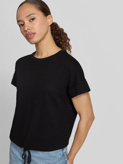 Frauenmodel trägt Regular Fit T-Shirt aus Viskose-Mix Modell 'Solke' von OPUS, schwarz, Strukturmuster, Tunnelzugsaum, Nahaufnahme Oberkörper.
