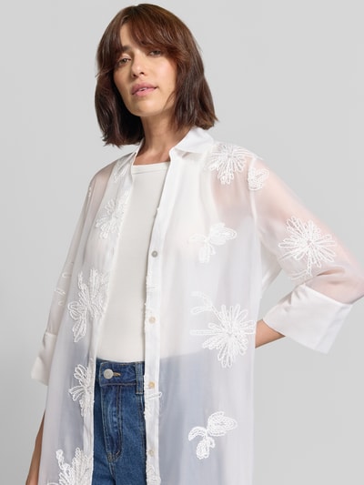 Frauenmodel trägt Regular Fit Langarmbluse mit floral-Stitching von s.Oliver BLACK LABEL in Weiß, transparente Optik, Nahaufnahme Oberkörper.