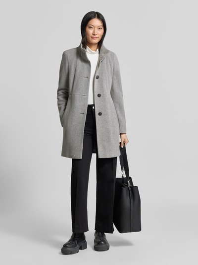 Frauenmodel trägt Regular Fit Mantel aus Woll-Mix von FUCHS SCHMITT in Grau mit Stehkragen und Knopfleiste, Ganzkörperansicht von vorne. Rückenlänge 84 cm, Schulterbreite 41 cm, Brustweite 47 cm, Ärmellänge 67 cm.