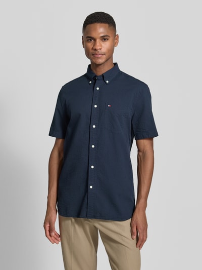 Männermodel trägt Regular Fit Freizeithemd aus reiner Baumwolle von Tommy Hilfiger, unifarben, strukturierte Optik, Ganzkörperansicht von vorne.