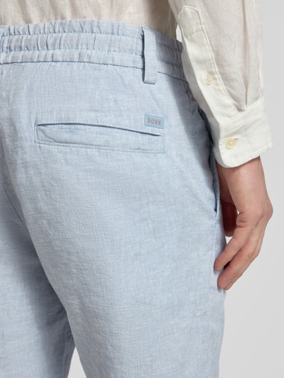 Männermodel trägt Tapered Chinoshorts aus Leinen-Mix Modell 'DS_3S' von BOSS Orange in Hellblau, Flammgarn, Detailaufnahme Rückansicht.