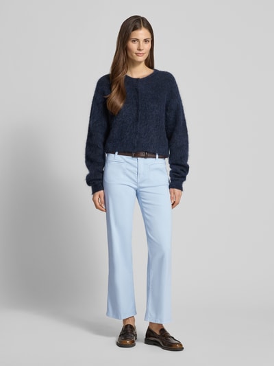 Modelka nosi Cropped Jeans mit Bügelfalten und Eingrifftaschen von Cambio, mieszanka bawełny z dodatkiem streczu, krój krótki, kanty, wpuszczane kieszenie, szerokość w rozmiarze 36: 39 cm, długość wewnętrzna nogawki w rozmiarze 36: 70 cm, jasnoniebieskie, proste nogawki, gładka faktura, Ganzkörperansicht von vorne.