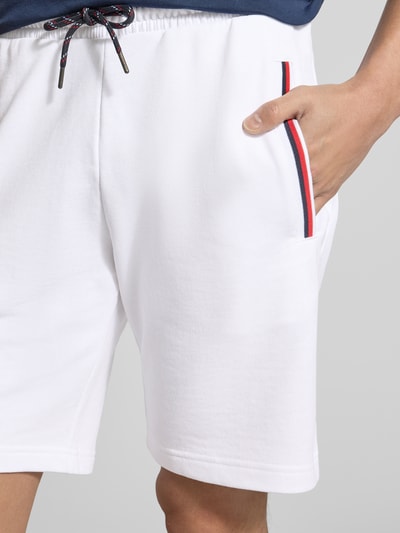 Männermodel trägt Shorts mit elastischem Bund von Christian Berg Men aus Baumwoll-Elasthan-Mix, Eingrifftaschen mit Kontraststreifen, Nahaufnahme Oberkörper.