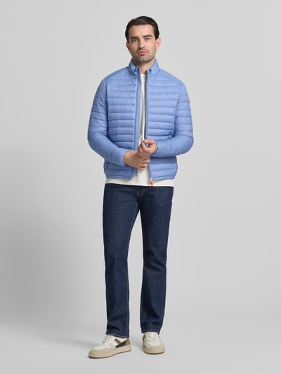 Männermodel trägt Steppjacke mit Zweiwegereißverschluss Modell 'Alexander' von SAVE THE DUCK in Hellblau, Regular Fit, Ganzkörperansicht von vorne.