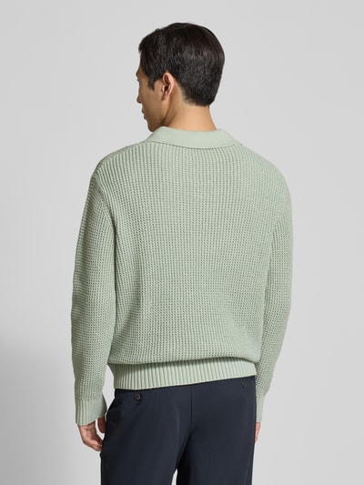 Männermodel trägt Relaxed Fit Strickpullover aus reiner Baumwolle Modell 'DERECK' von SELECTED HOMME, grobstrick, unifarben, ganzkörperansicht rückansicht.