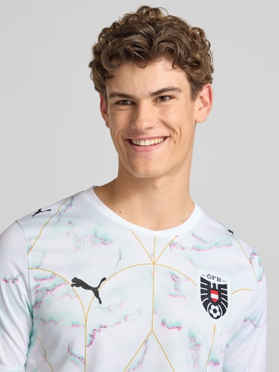 Männermodel trägt Österreich Auswärtstrikot 2026 von PUMA PERFORMANCE mit Label-Stitching, Rundhalsausschnitt, Nahaufnahme Oberkörper.