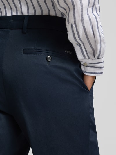 Mężczyzna nosi Slim Fit Hose aus Baumwoll-Mix Modell 'H-GENIUS' od BOSS, granatowy twill, detal tylnej kieszeni, zbliżenie na biodro.