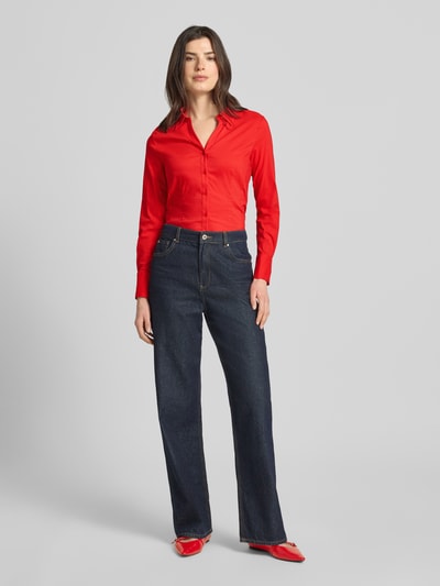 Frauenmodel trägt Regular Fit Hemdbluse in langärmeligen Design Modell 'Februar' von More & More in Rot, Ganzkörperansicht von vorne. Elastischer Baumwoll-Mix, Hemdblusenkragen, durchgängige Knopfleiste, taillierte Passform, Rückenlänge bei Größe 36: 65 cm, Ärmellänge bei Größe 36: 60 cm.