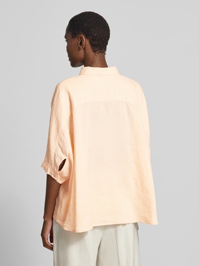 Frauenmodel trägt Relaxed Fit Leinenbluse mit Brusttasche von Emily Van den Bergh in hellem Ton, reine Leinen, 3/4-Arm, Rückenlänge 63 cm, Ärmellänge 33 cm, Ganzkörperansicht Rückansicht.