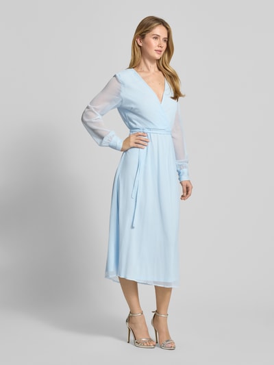 Frauenmodel trägt Midikleid mit Taillenband Modell 'FALIA' von Vila in Hellblau, Wickel-Optik, semitransparente lange Ärmel, taillierte Passform, blickdichter Unterrock, V-Ausschnitt, Ganzkörperansicht von vorne. Rückenlänge 127 cm, Brustweite 47 cm, Ärmellänge 66 cm.