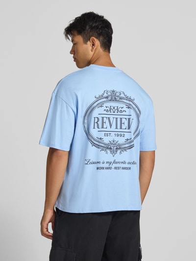 Männermodel trägt Regular Fit T-Shirt aus reiner Baumwolle mit rückseitigem Print von REVIEW, hellblau, lockere Form, Ganzkörperansicht Rückansicht.