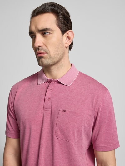 Männermodel trägt Regular Fit Poloshirt mit Brusttasche von Christian Berg Men aus Material-Mix mit Baumwoll-Anteil, Nahaufnahme Oberkörper.