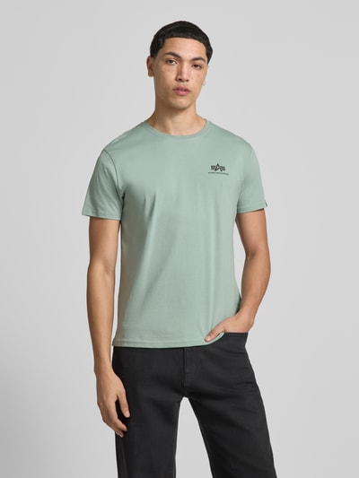 Männermodel trägt T-Shirt mit Label-Details Modell 'BASIC' von Alpha Industries in Hellgrün aus Reine Baumwolle, Gerader-Schnitt, Nahaufnahme Oberkörper.