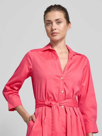 Vrouwenmodel draagt Hemdblusenkleid met Bindegürtel Modell 'JULE' van 0039 Italy, felroze kleur, katoenmix met stretch, a-lijn, knielang, v-hals, bindriem, zichtbare knopen, gladde textuur, detailopname bovenlichaam.