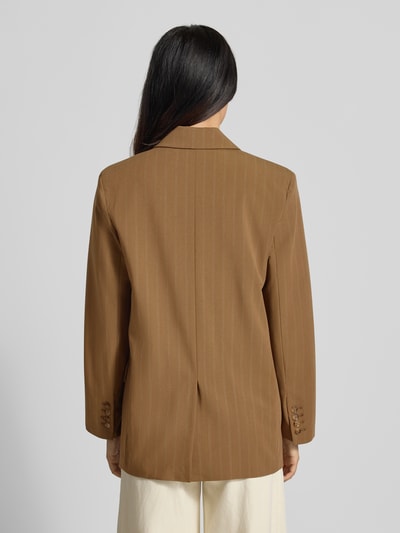 Frauenmodel trägt Relaxed Fit Blazer mit Pattentaschen Modell 'SYSTECK' von Mango in Braun mit feiner Nadelstreifen-Struktur, Ganzkörperansicht Rückansicht. Material-Mix mit Woll-Anteil, Reverskragen, Knopfverschluss, Rückenlänge 73 cm, Brustweite 45 cm, Ärmellänge 60 cm.
