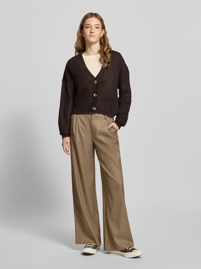 Frauenmodel trägt Regular Fit Strickjacke mit einreihiger Knopfleiste Modell 'CAROL NICE' von Only, braun, Strickoptik, Ganzkörperansicht von vorne.