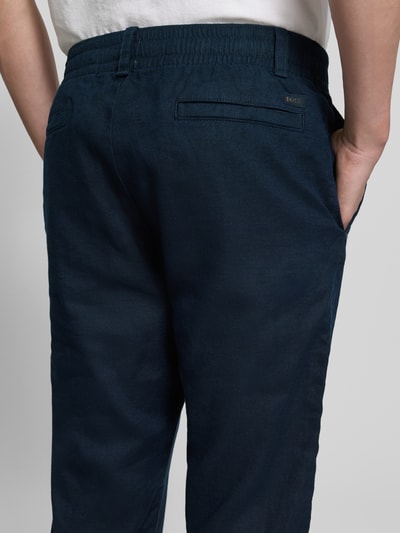 Mannenmodel draagt Regular Fit Leinenhose uit linnenmix model 'Sanderson-L-3' van BOSS, effen kleuren, webstof, detailopname achterkant.