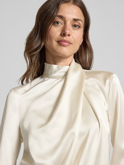 Frauenmodel trägt Regular Fit Langarmbluse aus Satin von Jake*s, cremefarben mit glatter Oberfläche, Nahaufnahme Oberkörper, Damen Langarmbluse von Jake*s Collection.