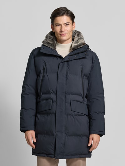 Männermodel trägt Regular Fit Steppmantel mit abnehmbaren Kapuze Modell 'Ambience' von Strellson in Dunkelblau, Ganzkörperansicht von vorne, Herren Steppmantel von Strellson.