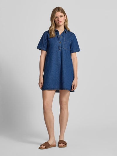 Frauenmodel trägt Relaxed Fit Minikleid in Denim-Optik Modell 'Amara' von JJXX, reine Baumwolle, kurzärmelig, Ganzkörperansicht von vorne.