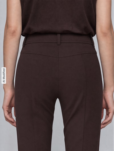 Vrouwenmodel draagt donkerbruine slim fit broek met opgestikte zakken model 'FARAH' van CAMBIO, Dames, detailopname rugaanzicht.