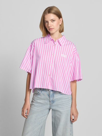 Frauenmodel trägt Cropped Bluse mit Label-Stitching Modell 'VEXTOWN' von American Vintage, rosa-weiß gestreift, reine Baumwolle, Nahaufnahme Oberkörper.