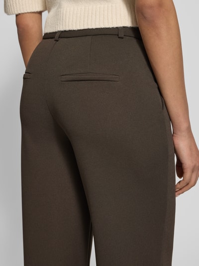 Kobieta prezentuje Hose mit elastischem Bund Modell 'Nathalie' od Neo Noir z szerokimi nogawkami, materiał z domieszką stretchu, kolor brązowy, detaliczne faktury, widoczne tylne kieszenie, Szerokość w rozmiarze 36: 36 cm, długość nogawki od wewnątrz: 81 cm, detaliczne ujęcie tylnej części spodni