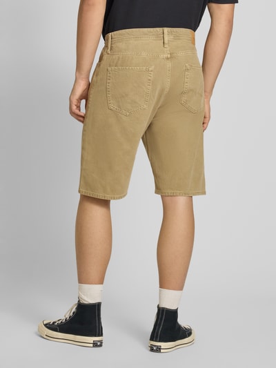 Männermodel trägt Baggy Fit Jeansshorts Modell 'ALEX' von Jack & Jones in Beige, Baumwolle, sichtbare Eingrifftaschen, Ganzkörperansicht Rückansicht.