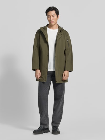 Männermodel trägt Regular Fit Jacke mit Kapuze Modell 'Spirit' von G-LAB aus Baumwoll-Mix in Oliv, Eingrifftaschen, Ganzkörperansicht von vorne.