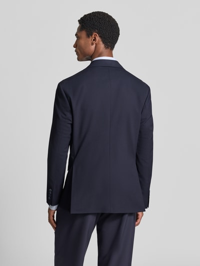 Männermodel trägt dunkelblaues, unifarbenes Relaxed Fit Anzugsakko mit Viskose-Anteil Modell 'LIAM' von Selected, Rückenschlitz, Pattentaschen, Ganzkörperansicht Rückansicht.